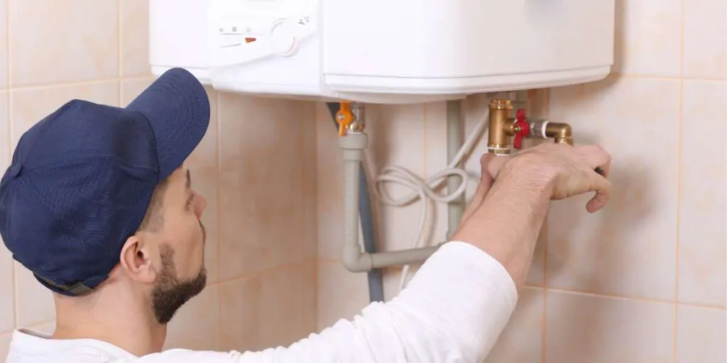 tecnico a reparar Fuga de água na caldeira na válvula de segurança